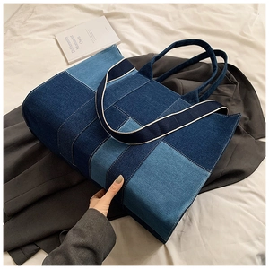 Close-up of color-block denim tote bag with dual straps and vertical patchwork design