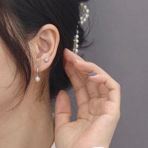 Close-up of model wearing silver flower earrings with clear sparkling crystals