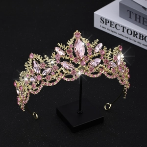 Detailed view of luxury gold bridal crown with pink crystals and intricate floral patterns