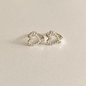 Macro shot of minimalist 925 silver heart stud earrings with beaded texture detail