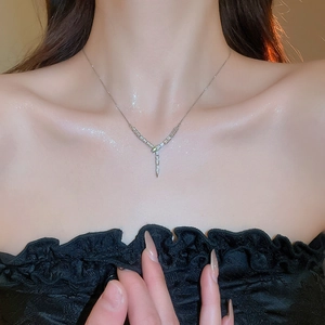 Macro shot of silver-colored Y-shaped necklace with sparkling zircon on model neck