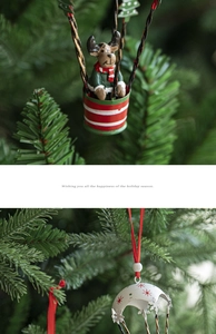 Close-up of two Nordic iron Christmas hot air balloon ornaments hanging on a pine tree