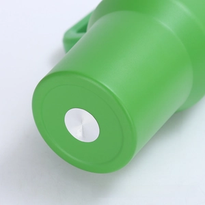 Detail view of the green insulated tumbler base with a brushed metal texture disk