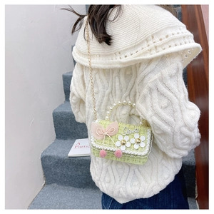Detail of green tweed kids crossbody bag with pearls and pink mesh bow decoration