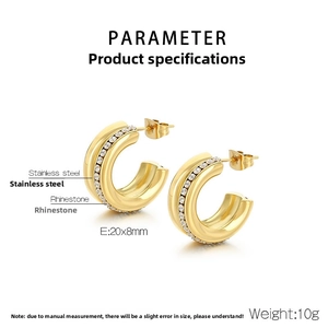 Close-up of golden C-shape stainless steel earrings with sparkling rhinestone details