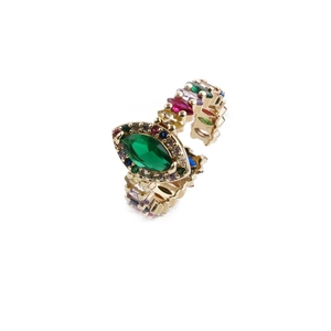Détail d'une bague dorée ajustable avec pierre marquise verte et zircons colorés
