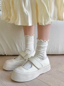 Detail of cream ruffle socks with vertical stripes and platform Mary Jane shoes