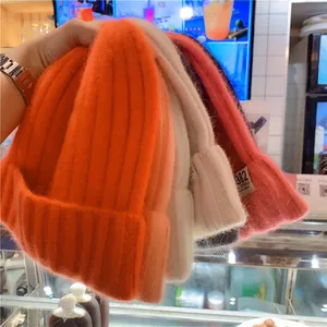 Close-up of soft knitted beanies in multiple colors with 982 California woven labels
