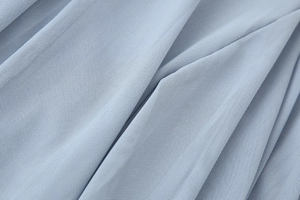 Makroaufnahme der hellblauen Mesh-Stoffstruktur dieses eleganten französischen Maxikleides
