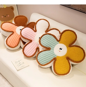 Soft flower-shaped plush cushions in various colors arranged neatly on a beige sofa