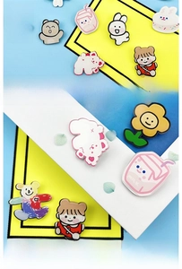 Close-up of cute cartoon acrylic pins featuring brown bear and bunny on colorful background