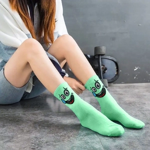 Detail of light green ribbed crew socks featuring funny cartoon character facial expressions