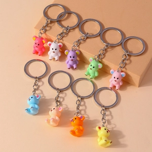 Detailed view of nine colorful cartoon bear keychains in resin on beige display cubes