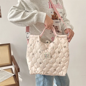 Détail du sac fourre-tout en coton matelassé rose avec bandoulière et texture douce en 3D
