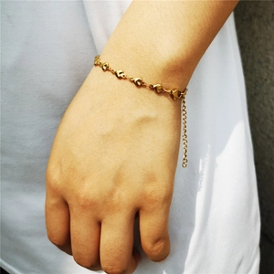 Détail du bracelet doré à maillons en cœur avec une chaîne de réglage et fermoir mousqueton