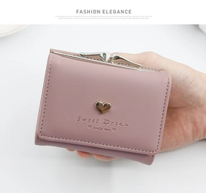 Detail of pink-purple trifold wallet with heart metal decor and kiss-lock closure
