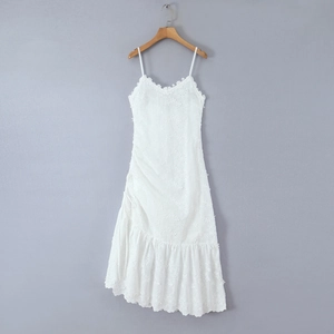 Gros plan d'une robe blanche avec broderie florale complexe et fines bretelles spaghetti