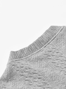 Macro detail of grey quilted jacquard fabric and ribbed collar on men's slim cardigan