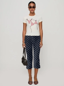 Detail of navy blue polka dot cropped pants featuring a stylish side slit at the hemline