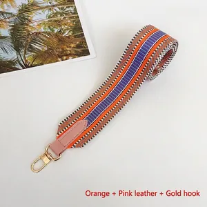 Close-up of colorful woven replacement shoulder strap with pink leather ends and gold hooks