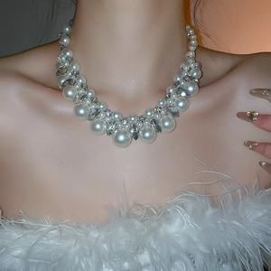 Detail of elegant pearl necklace with sparkling rhinestones on model's neck
