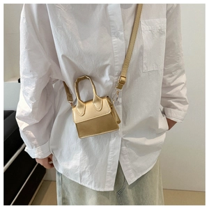 Detailansicht der gold-metallischen Mini-Handtasche als Umhängetasche getragen