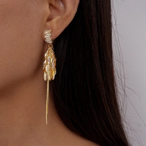 Macro shot of gold leaf tassel earrings featuring clear rectangular zircon stones
