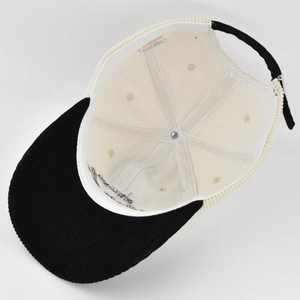 Detail view of corduroy baseball cap interior with 100% cotton label and metal buckle