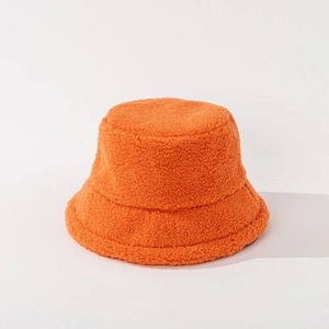 Macro view of bright orange lamb wool bucket hat texture showing thick fluffy plush fabric