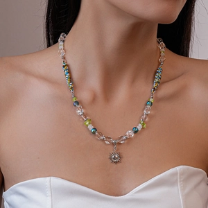 Détail du collier ethnique avec pendentif soleil et perles de verre colorées sur modèle