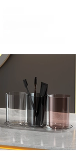 Detailed view of three transparent mouthwash cups in smoke and brown with a storage tray