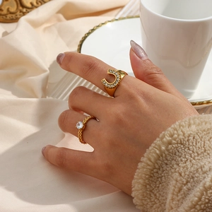 Close-up of 18K gold plated U-shaped and braided rings set with clear cubic zirconia