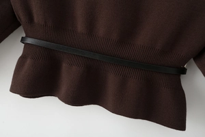 Detail of dark brown knit top featuring ribbed waist with slim black leather belt