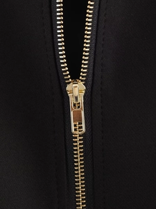 Nahaufnahme eines hochwertigen goldenen Metallreißverschlusses auf einer schwarzen Jacke