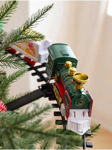 Macro view of electric Christmas train circling a festive tree with glowing details