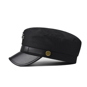 Detail view of black nautical captain hat with silver anchor emblem and leather brim