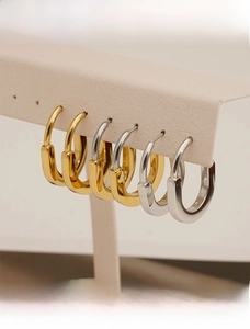 Detailed view of U-shaped stainless steel earrings in gold and silver finishes