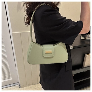 Detail of mint green baguette bag featuring sleek faux leather and gold metal buckle