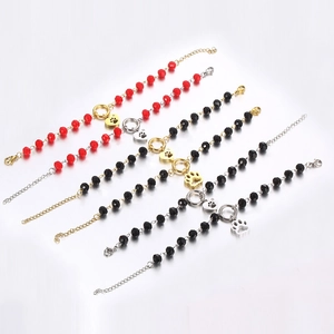 Detail of beaded bracelets with heart and paw pendants in red and black colors