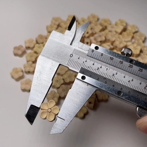 Perles en bois de buis mesurées au pied à coulisse montrant une taille de 11-12mm