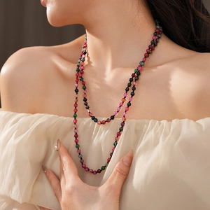 Close-up of bohemian multi-color long beaded necklace on model with crystal texture