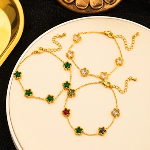 Detail view of 18K gold plated bracelets featuring colorful star-shaped gemstone pendants