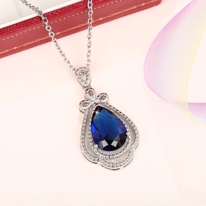 Elegant pear-shaped royal blue sapphire teardrop pendant necklace with a diamond halo