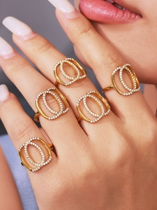 Detailed view of layered gold steel rings with zircon paving on female hand