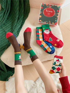 Close-up of festive Christmas cotton socks featuring Santa and tree patterns in a gift box