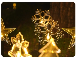 Close-up of glowing LED snowflake garden stake light with warm white Christmas lighting