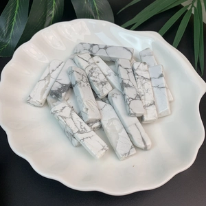 Macro shot of rectangular white marble stone beads with grey veins on a shell ceramic plate