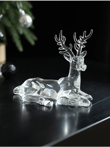 Detailed macro view of a clear acrylic lying reindeer statue with crystal reflections