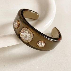 Macro shot of brown resin cuff bracelet featuring vintage square and round crystals