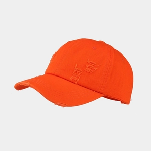 Close-up of bright orange washed cotton baseball cap with distressed torn details
